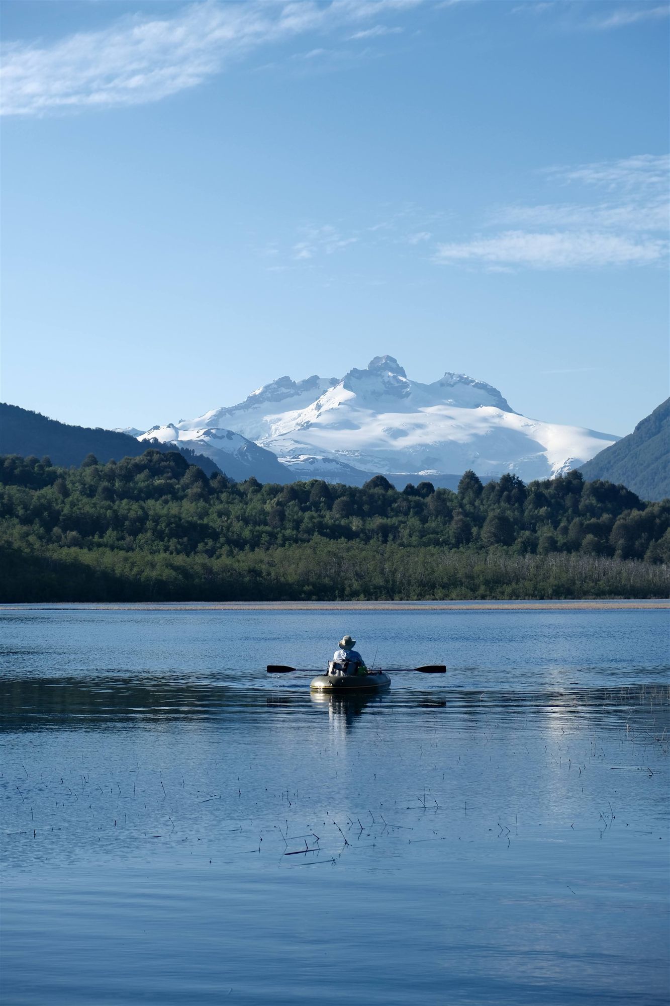 Une barque sur un lac face à un sommet enneigé